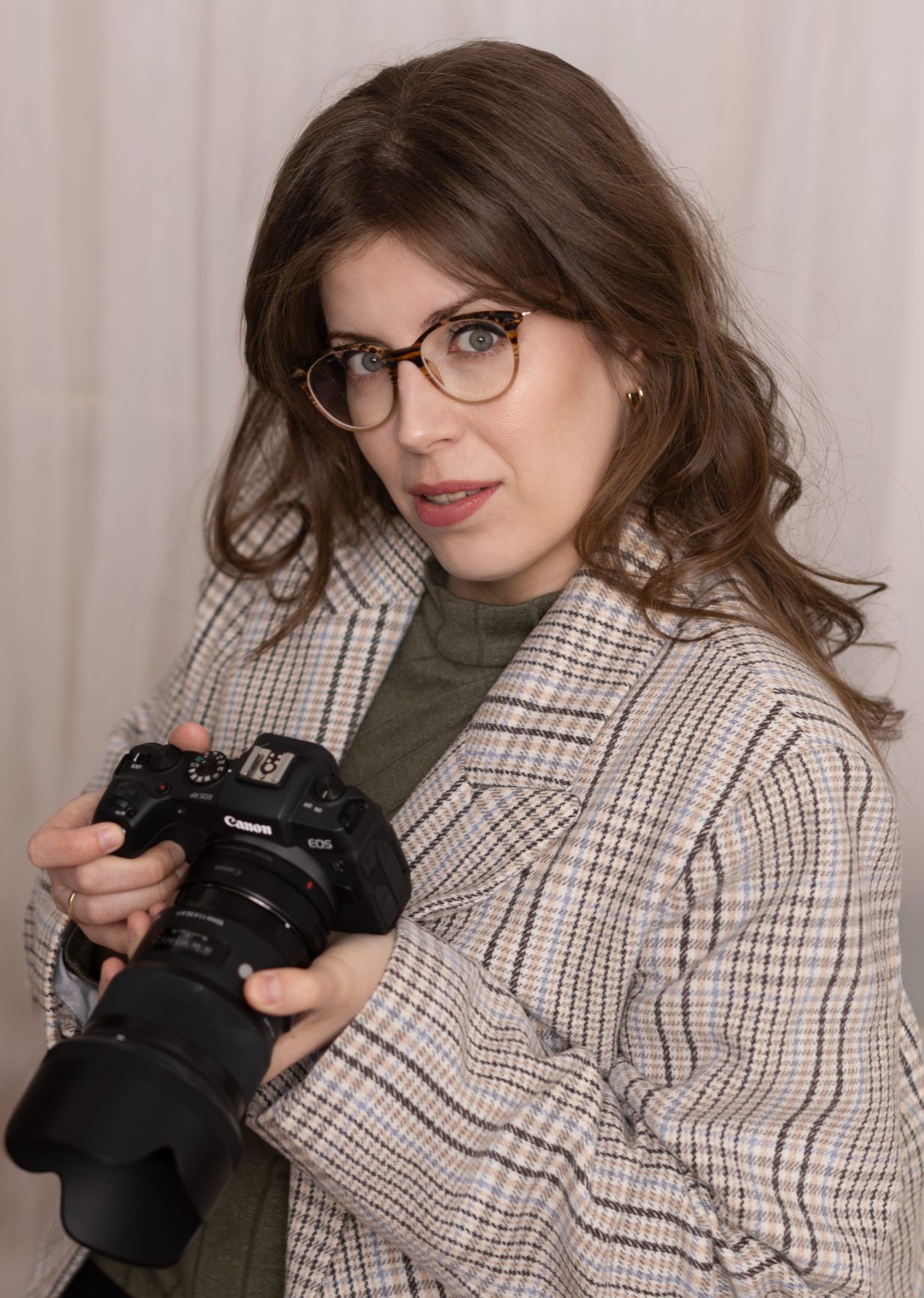 A fotós, Evelin egy fényképezőgépet tart a kezében.