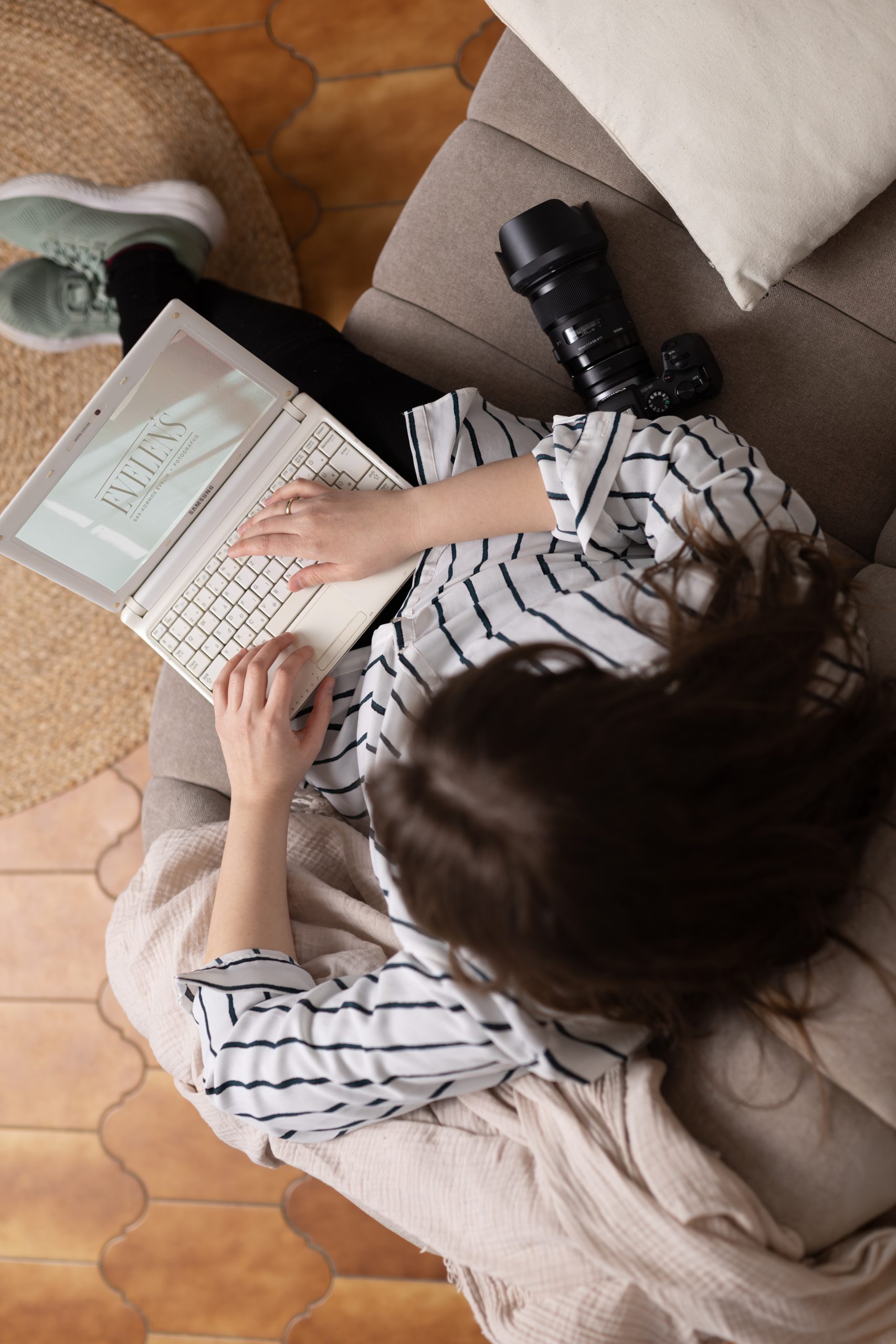 Az Evelens fotósa, Evelin laptopot tart az ölében és a brand logója látszik.