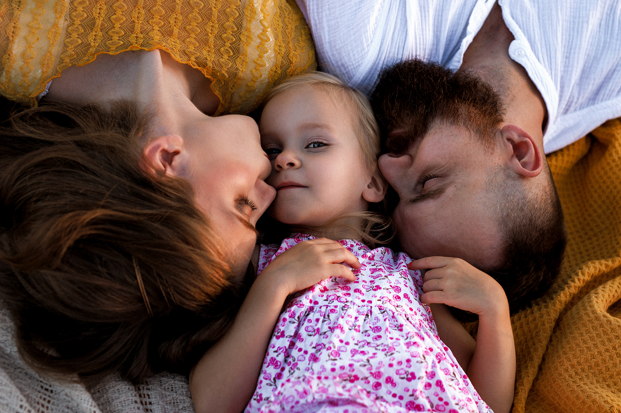 Családi portré, anyuka puszilja a kislányát.