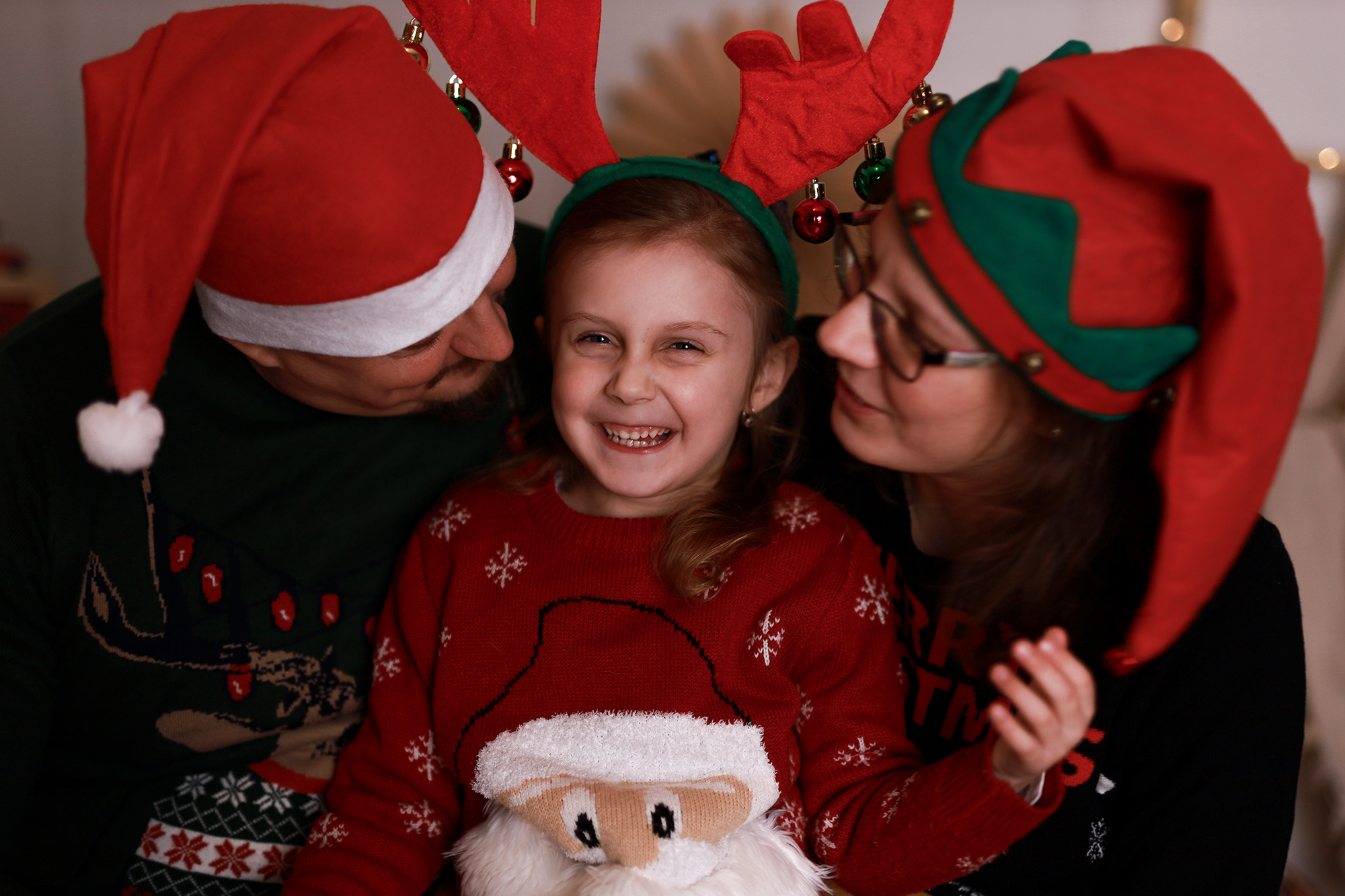 Karácsonyi családi puszilkodós kép manósapkában. 