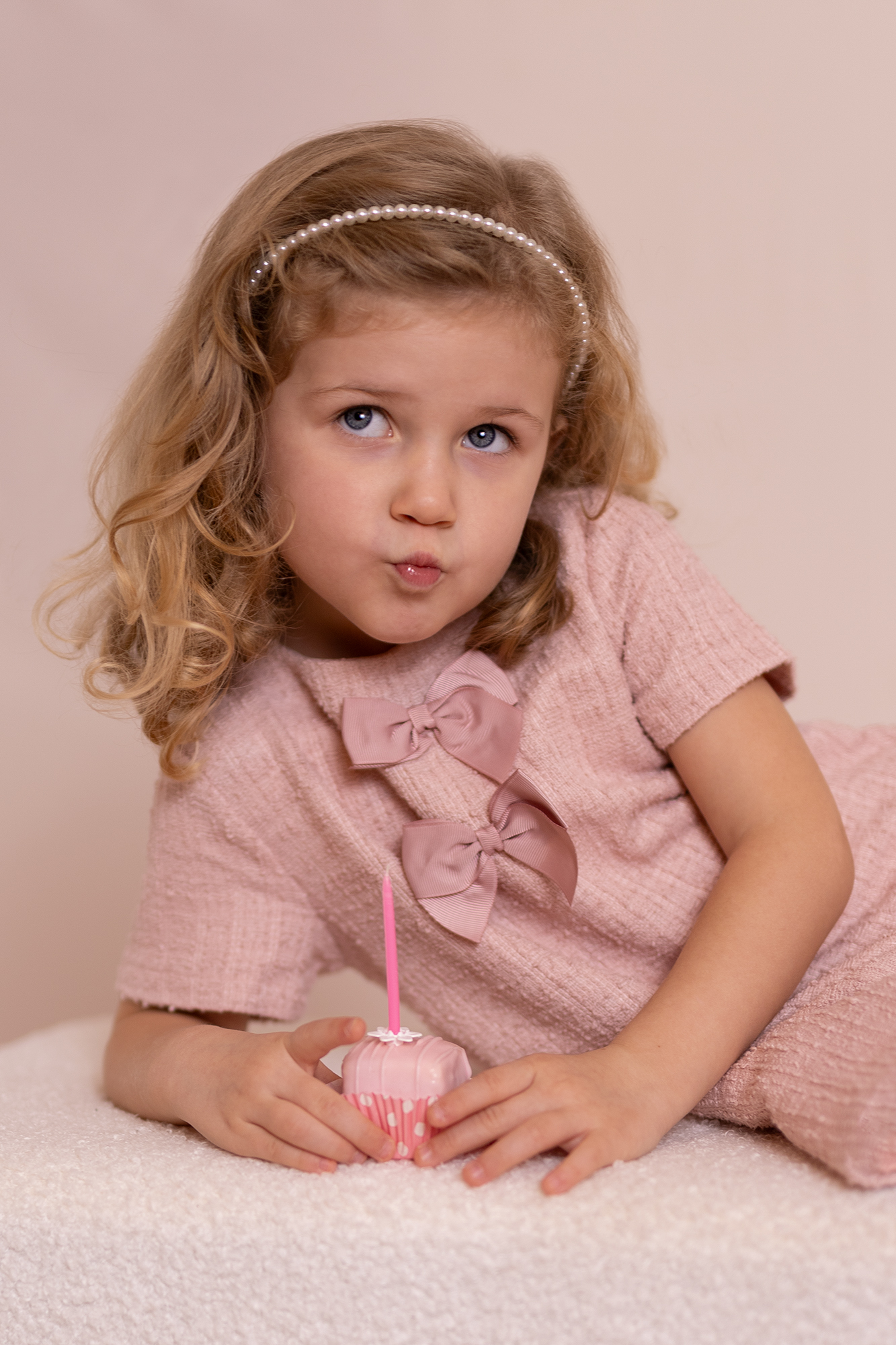 Szülinapos kislány üstivel a kezében csücsörítve pózol.