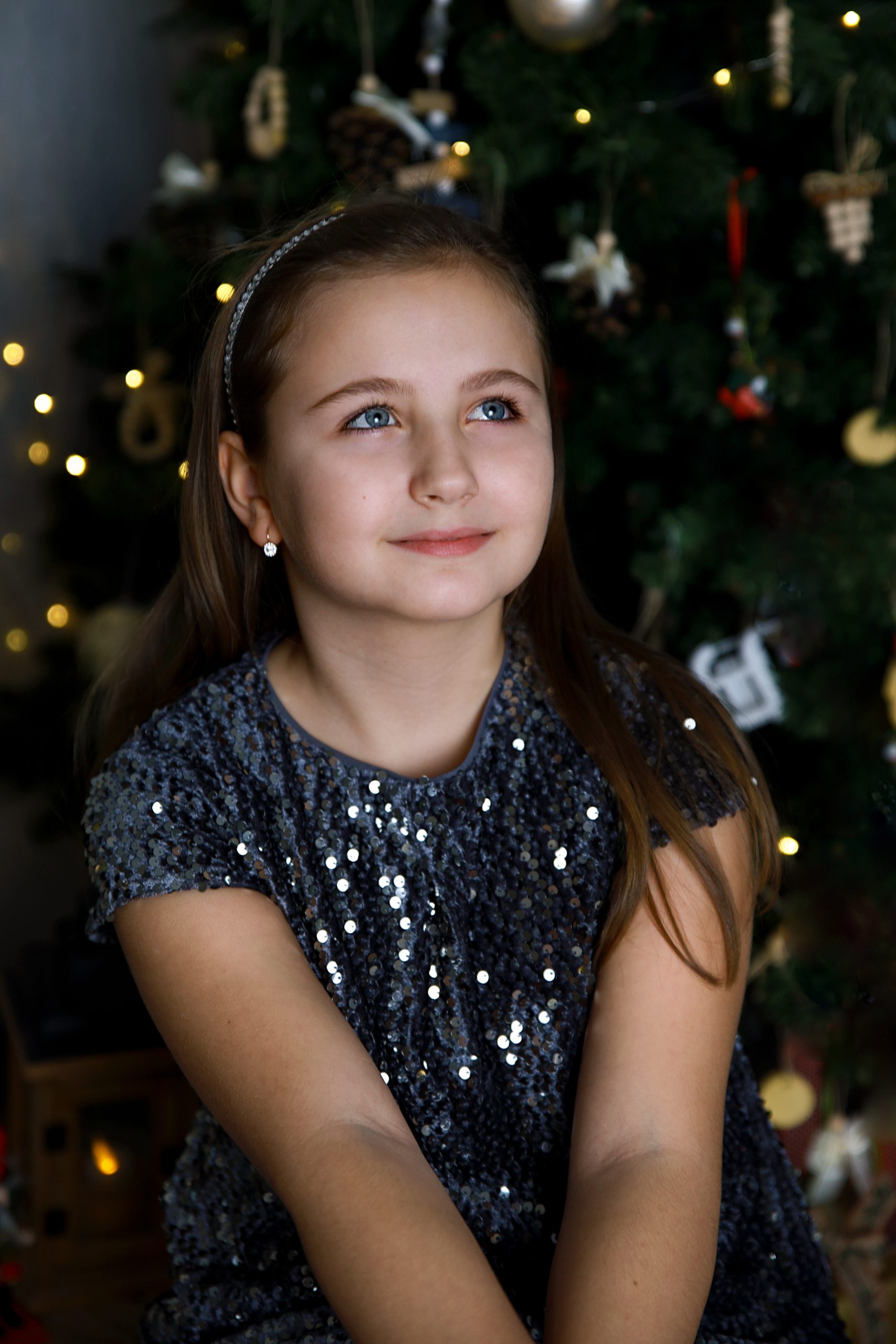 nagylány elegánsan ruhában pózol és felfelé néz mosolyogva